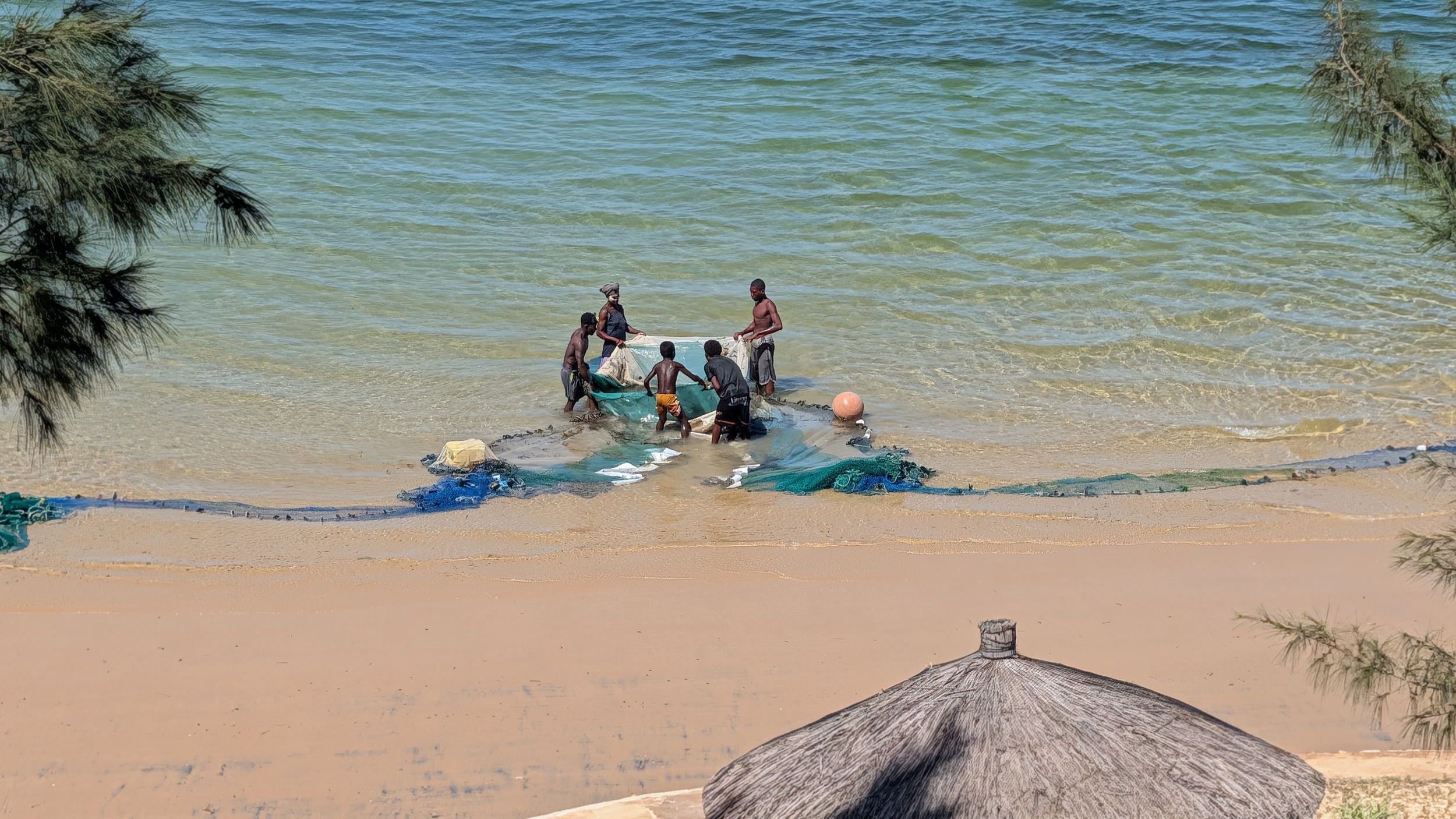 Fischer holen am Strand vor dem Hotel den Fang ein